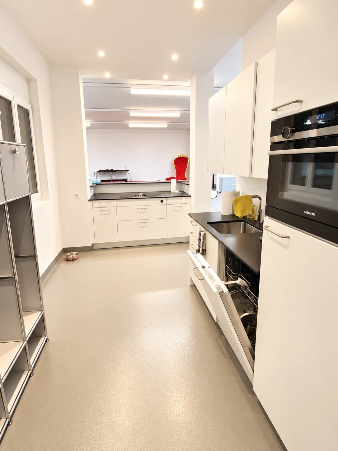 Neue Küche mit Bar und Epoxidharzboden, im Hintergrund die Büro- und Ladenfläche