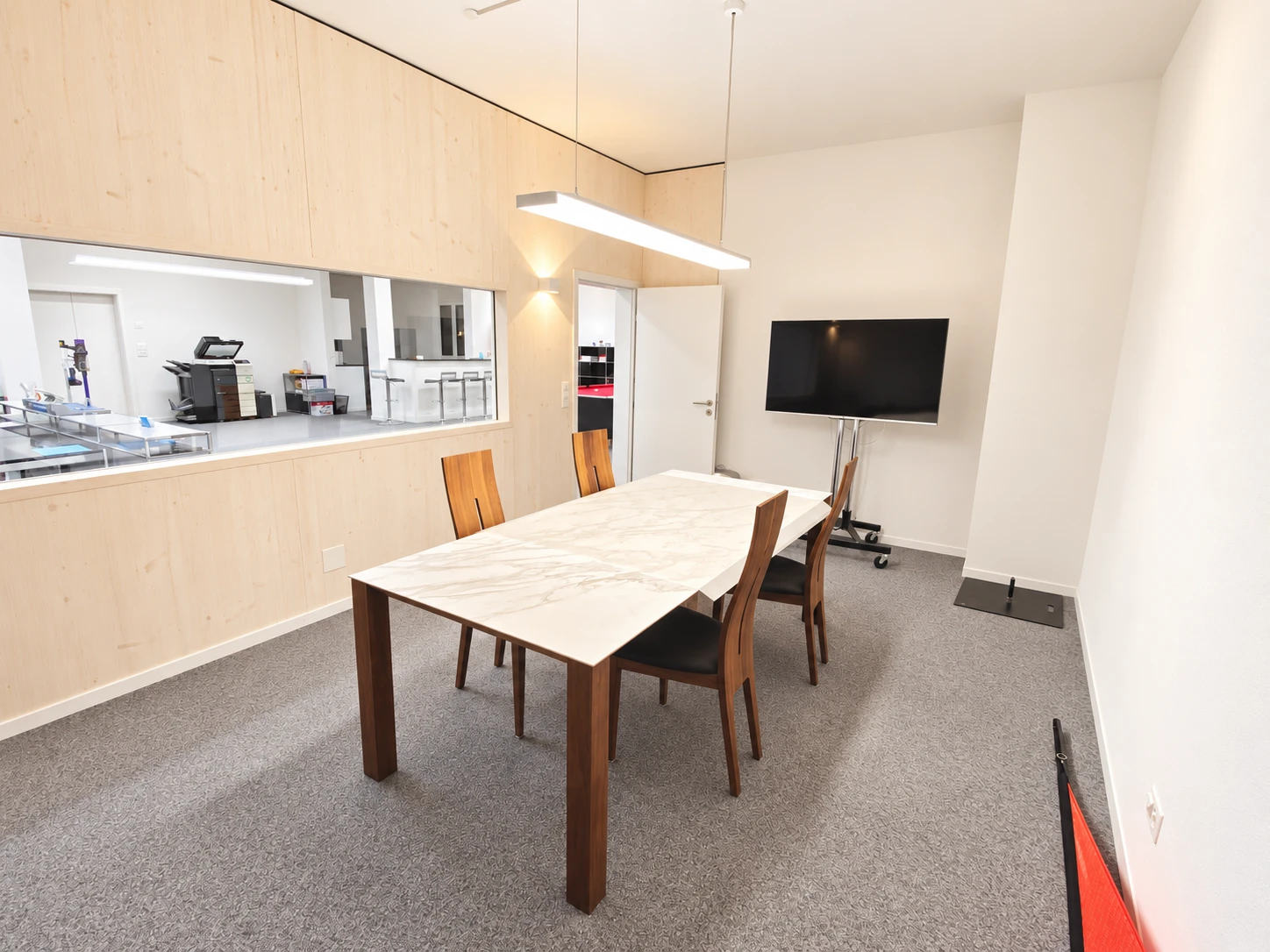 Eingebautes Sitzungszimmer mit Sichtfenster, Konferenztisch und Bildschirm
